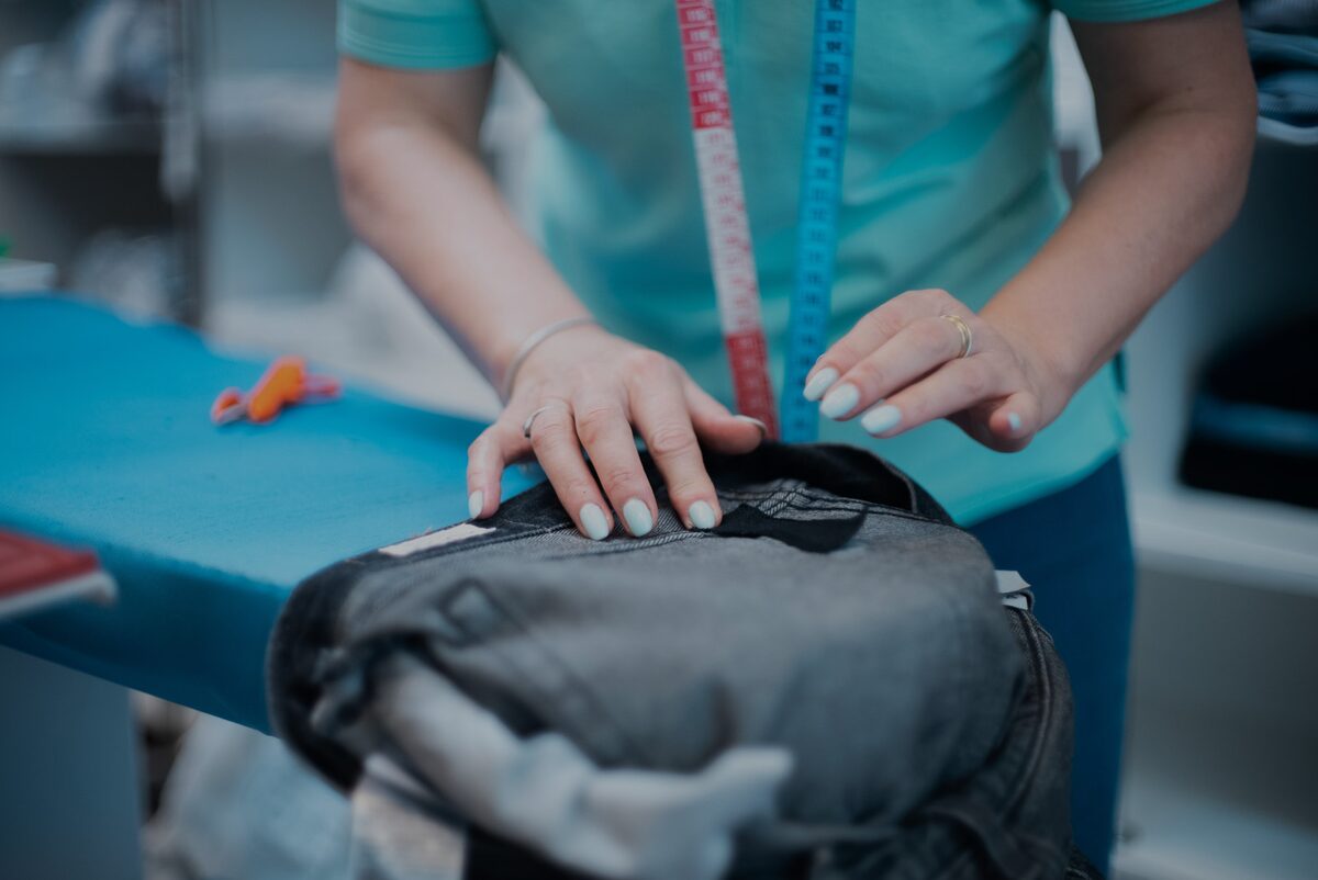Croitoreasă măsurând o pereche de blugi pentru retuș la Soft Clean